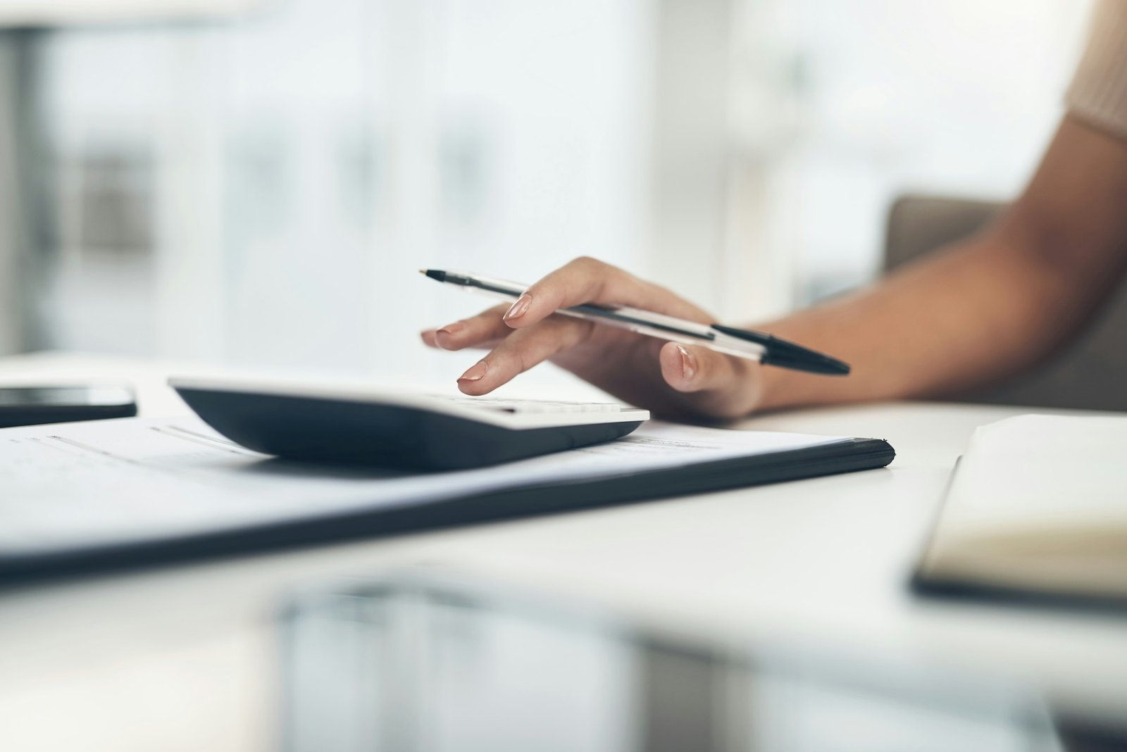 Closeup shot of an unrecognisable businesswoman calculating finances in an office